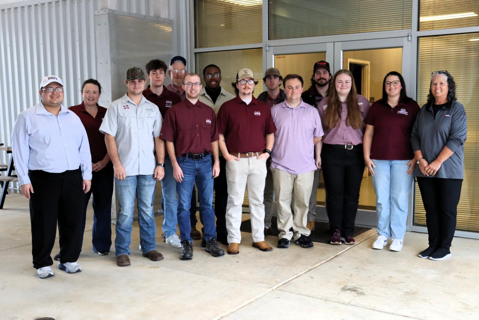 MSU students and faculty pose for a group photo outside a building